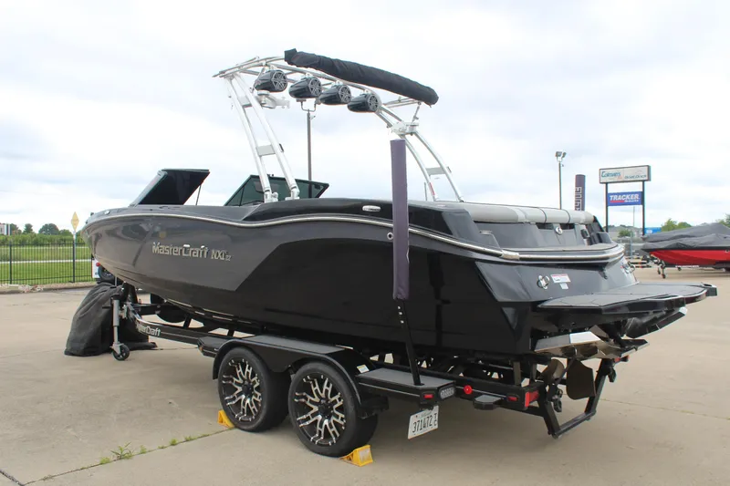 Slide: The Image of 2017 MasterCraft NXT22 boat on trailer, sleek black design, parked outdoors. - 6