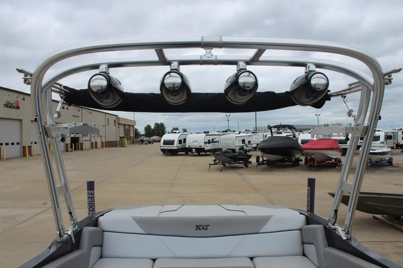 Slide: The Image of 2017 MasterCraft NXT22 boat with wakeboard tower and speakers, parked at a dealership. - 19