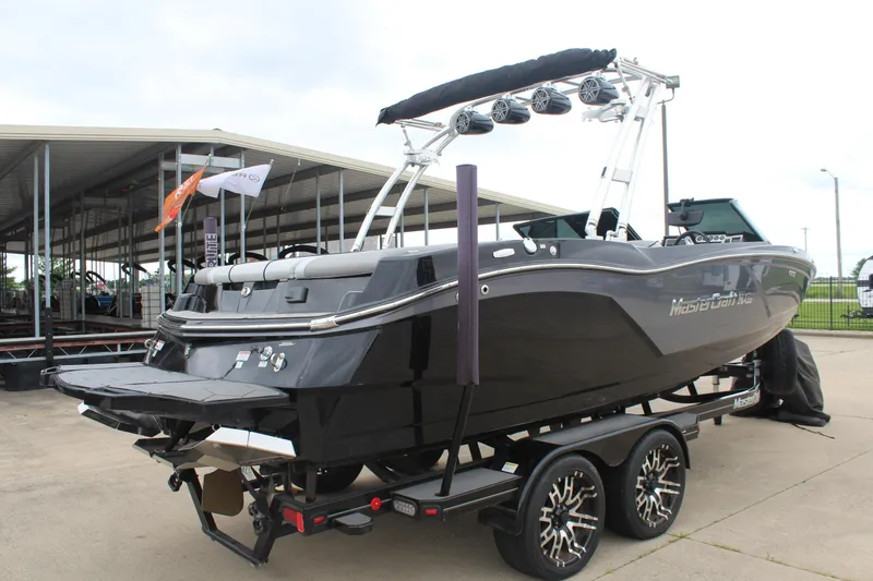 Slide: The Image of 2017 MasterCraft NXT22 boat on trailer, sleek black design, docked at marina. - 8