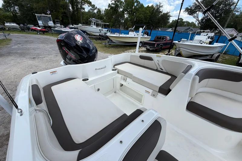 Slide: The Image of 2023 Bayliner Element E18 boat interior with seating and outboard motor in a marina setting. - 9