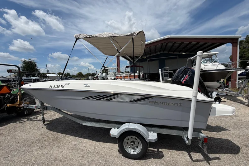The Image of 2023 Bayliner Element E18 boat on trailer under a clear blue sky. - 1