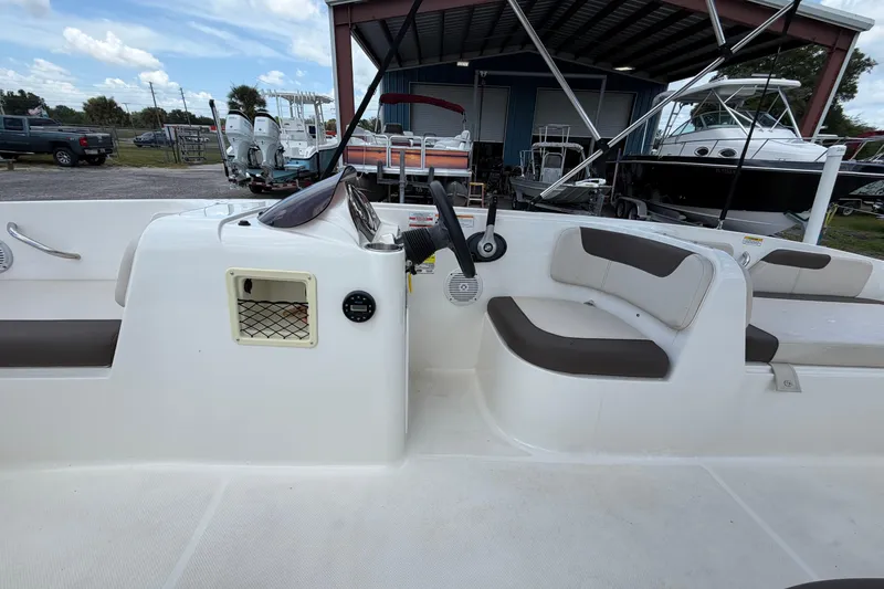 Slide: The Image of 2023 Bayliner Element E18 boat interior with seating and steering console. - 11