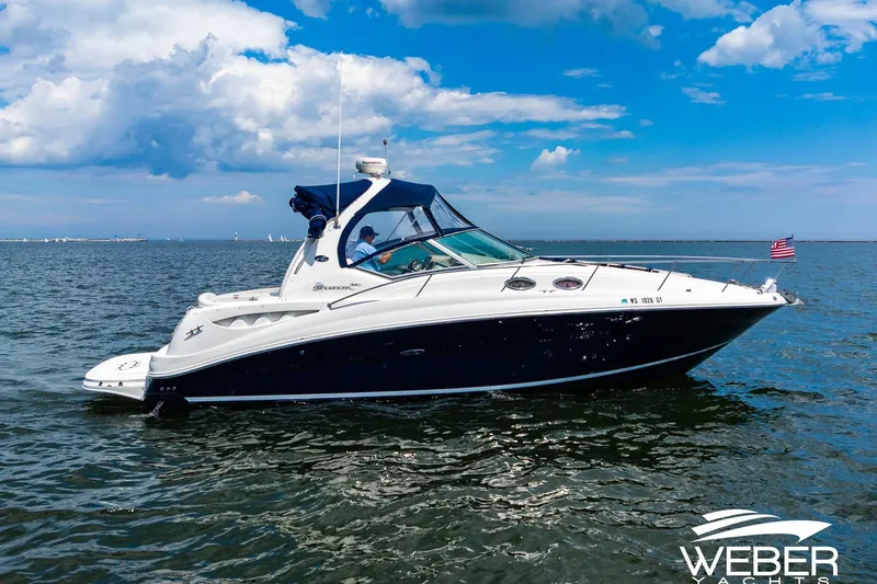 Slide: The Image of 2004 Sea Ray Sundancer 320 yacht cruising on open water under a blue sky. - 27