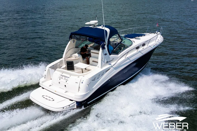 Slide: The Image of 2004 Sea Ray Sundancer 320 cruising on open water, featuring sleek design and blue canopy. - 1