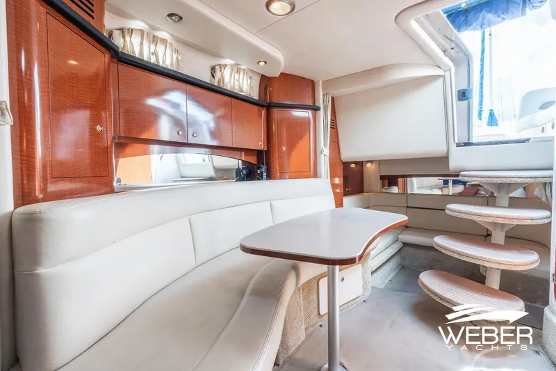 Slide: The Image of 2004 Sea Ray Sundancer 320 interior with elegant seating, wooden cabinetry, and spiral staircase. - 12