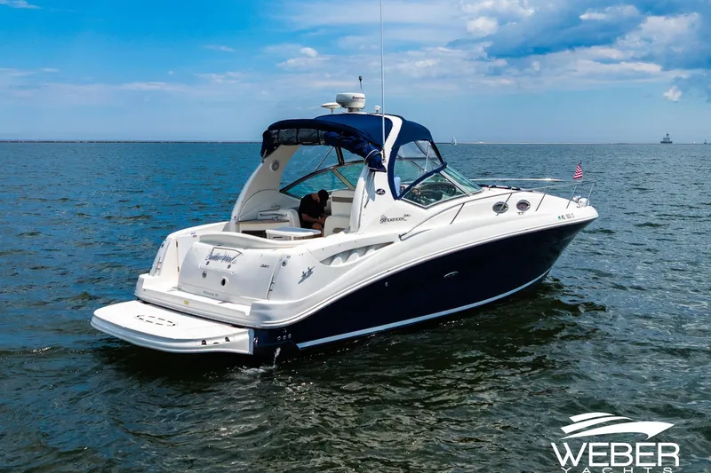 Slide: The Image of 2004 Sea Ray Sundancer 320 yacht cruising on open water under a clear blue sky. - 26