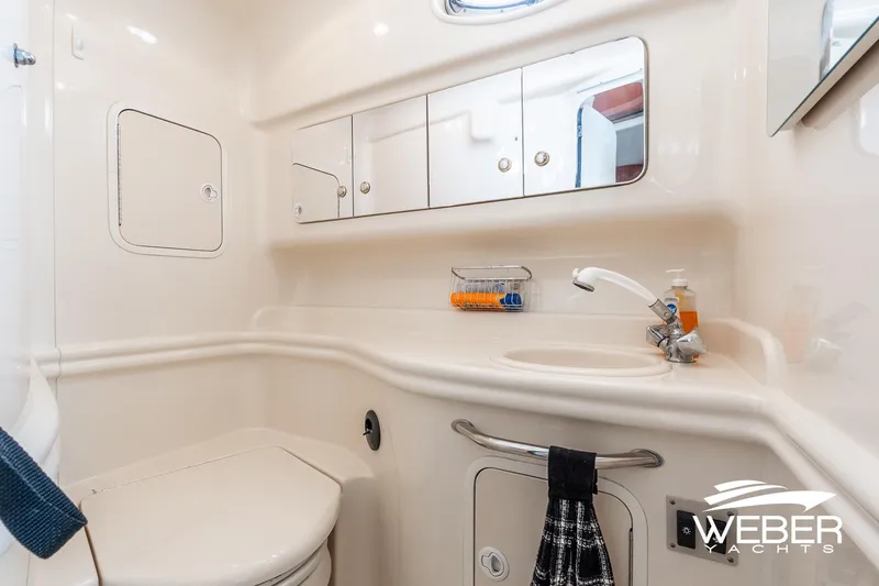 Slide: The Image of 2004 Sea Ray Sundancer 320 yacht bathroom with sink, mirror, and storage cabinets. - 18