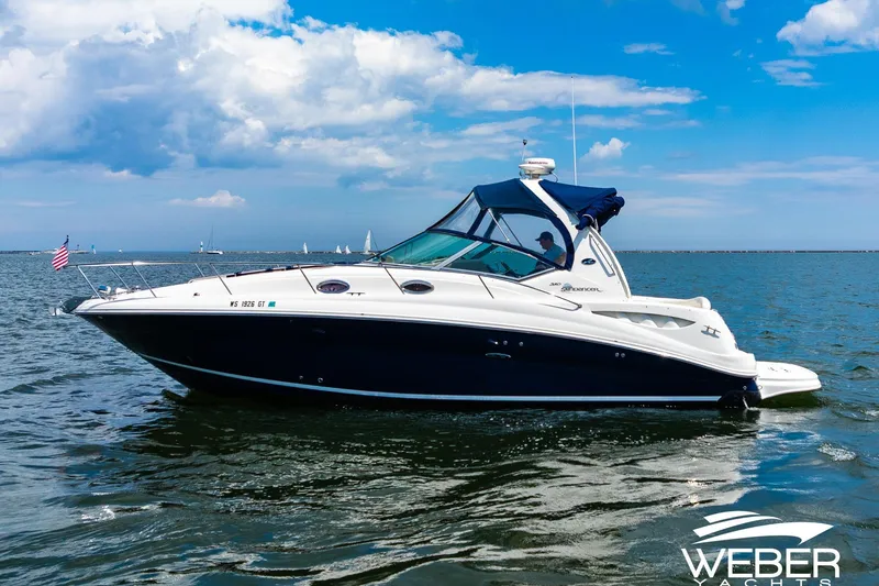 Slide: The Image of 2004 Sea Ray Sundancer 320 yacht cruising on open water under a blue sky. - 29