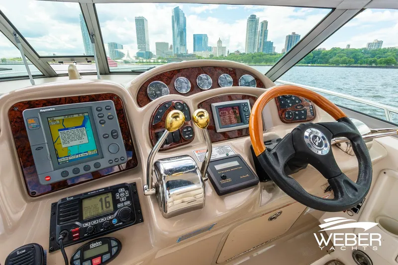Slide: The Image of 2004 Sea Ray Sundancer 320 helm with city skyline view, featuring navigation and control systems. - 24