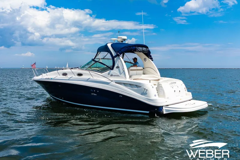 Slide: The Image of 2004 Sea Ray Sundancer 320 yacht cruising on open water under a clear blue sky. - 28