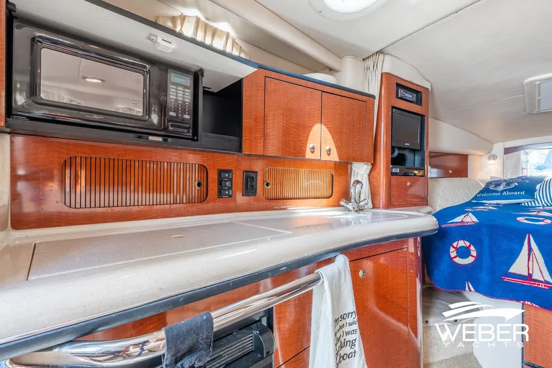 Slide: The Image of 2004 Sea Ray Sundancer 320 interior with kitchenette and cozy sleeping area. - 13
