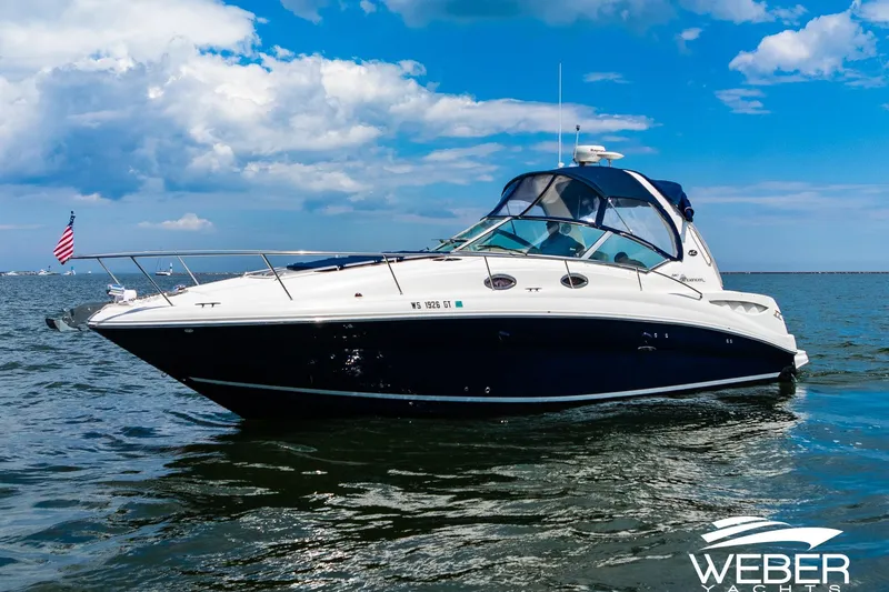 Slide: The Image of 2004 Sea Ray Sundancer 320 yacht on open water under a blue sky. - 30