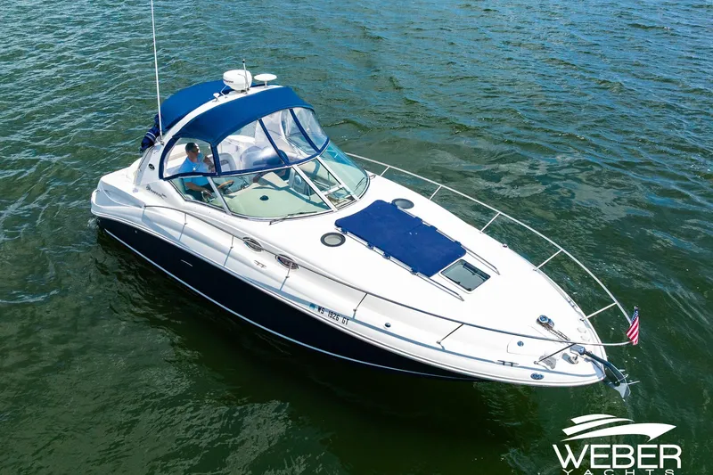 Slide: The Image of 2004 Sea Ray Sundancer 320 yacht cruising on open water, featuring sleek design and blue canopy. - 31