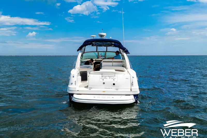 Slide: The Image of 2004 Sea Ray Sundancer 320 yacht cruising on open water under a clear blue sky. - 35