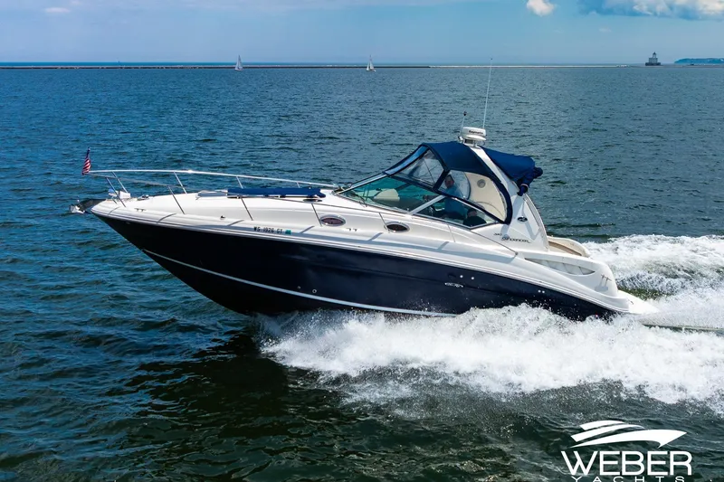 The Image of 2004 Sea Ray Sundancer 320 cruising on open water under clear skies. - 0
