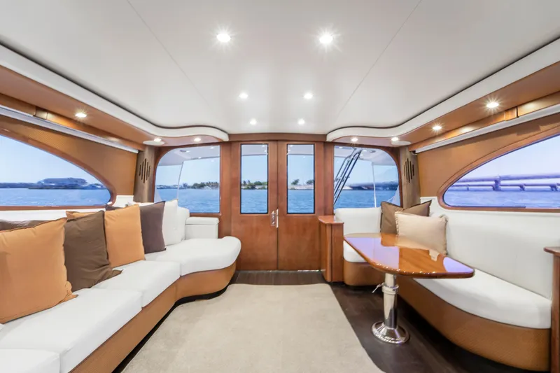 Slide: The Image of Interior of a luxury yacht with white sofas and a wooden table, surrounded by large windows. - 34