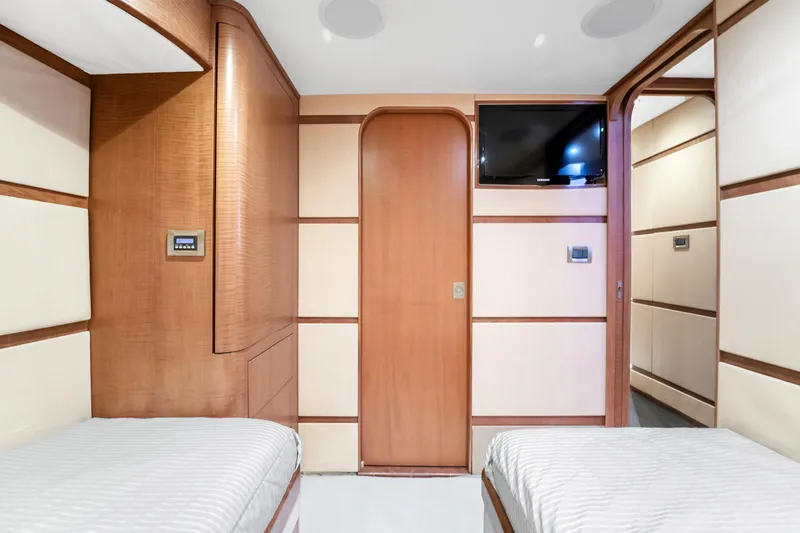 Slide: The Image of Interior of a modern yacht with two single beds, wood paneling, and a flat-screen TV. - 47