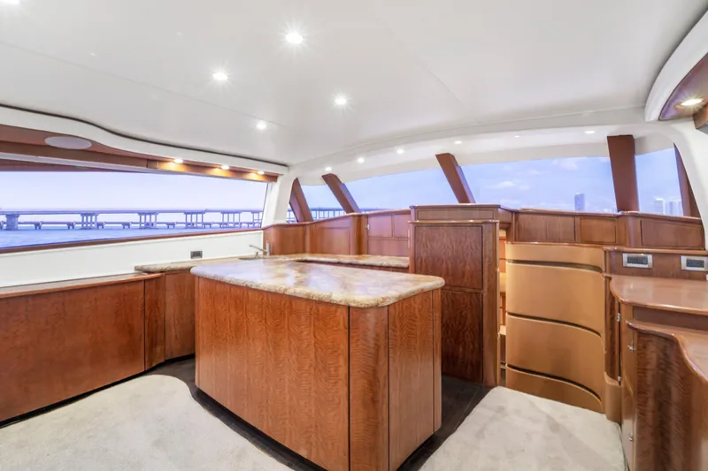 Slide: The Image of Interior of a luxury yacht with wooden furnishings and large windows offering a view of a bridge. - 40