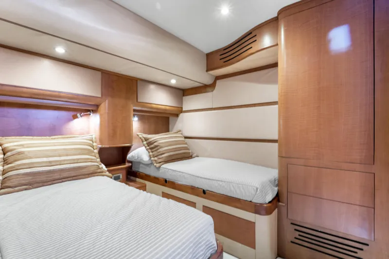 Slide: The Image of The cabin of a 2022 Garlington Convertible with two single beds and wooden furnishings. - 45