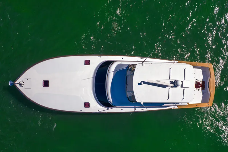 Slide: The Image of Aerial view of a sleek white yacht on green water, featuring a spacious deck and clean lines. - 20