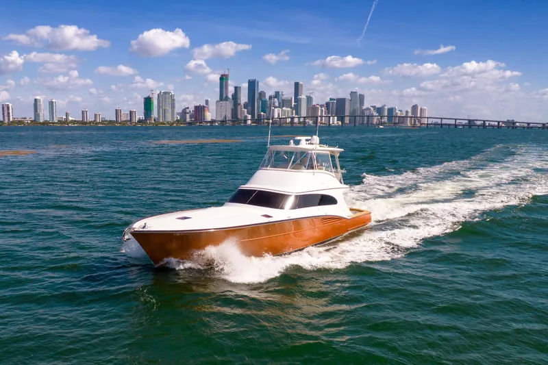 Slide: The Image of Garlington Convertible 2022 cruising on the water with a city skyline in the background. - 28