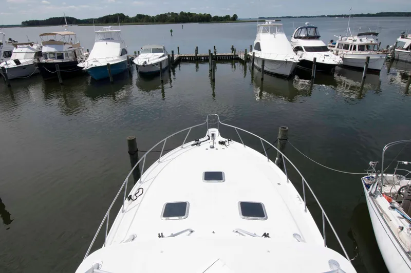 Slide: The Image of Bow view of a 2004 Tiara Yachts 4100 Open docked among other boats. - 17