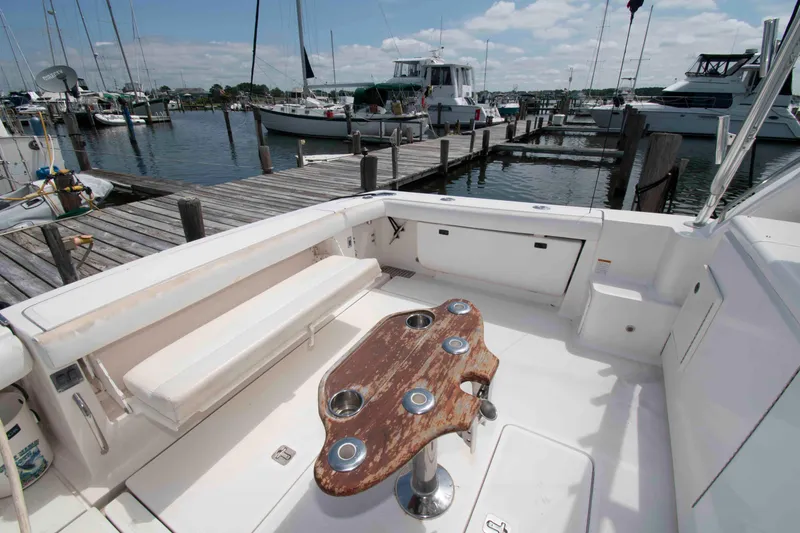 Slide: The Image of 2004 Tiara Yachts 4100 Open cockpit with seating and wooden table at marina. - 5