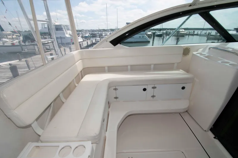 Slide: The Image of 2004 Tiara Yachts 4100 Open interior with white seating and storage, docked at marina. - 7