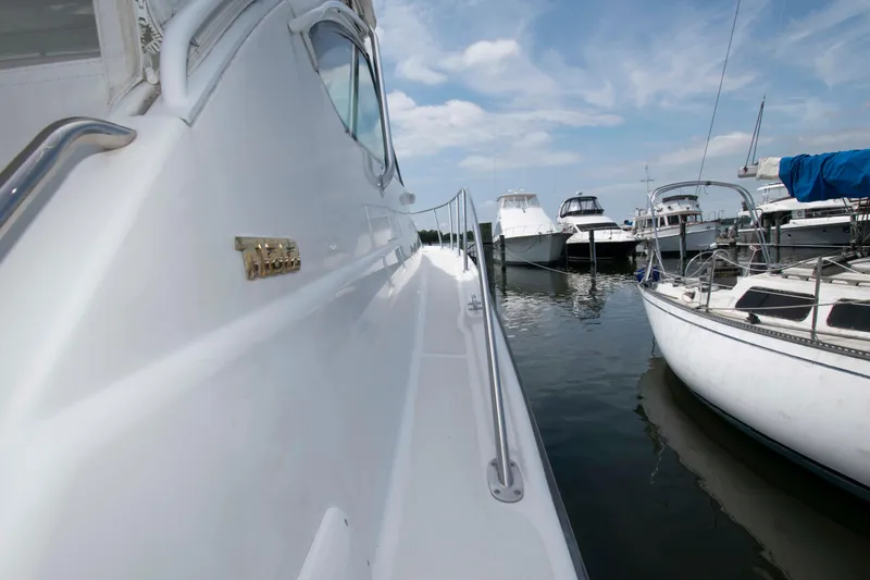 Slide: The Image of 2004 Tiara Yachts 4100 Open docked, showcasing sleek design and marina setting. - 13