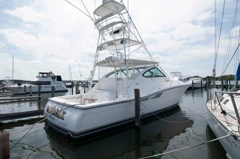 Slide: The Image of 2004 Tiara Yachts 4100 Open docked at a marina under a cloudy sky. - 1