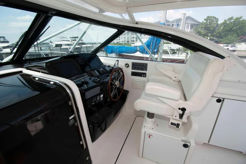 Slide: The Image of 2004 Tiara Yachts 4100 Open helm with white captain's chair and control panel. - 9