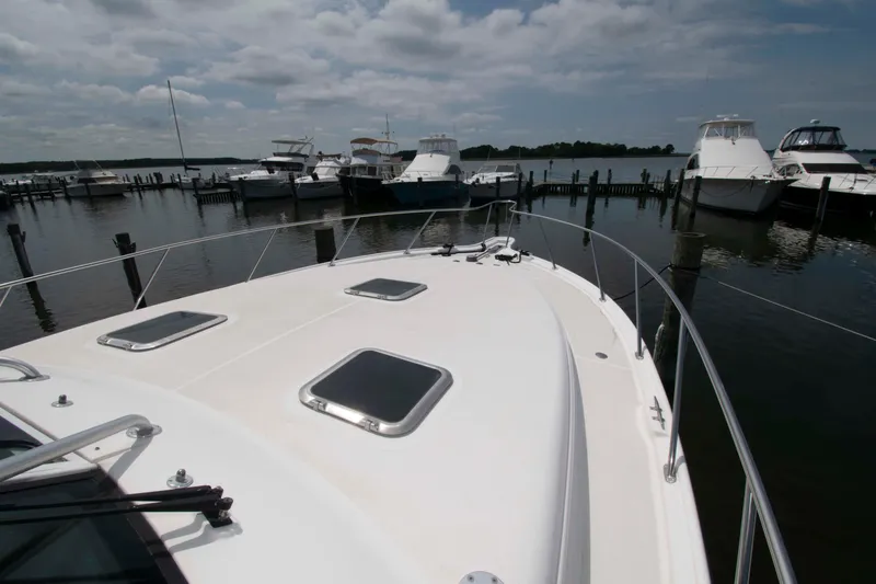 Slide: The Image of 2004 Tiara Yachts 4100 Open docked at marina under cloudy sky. - 14