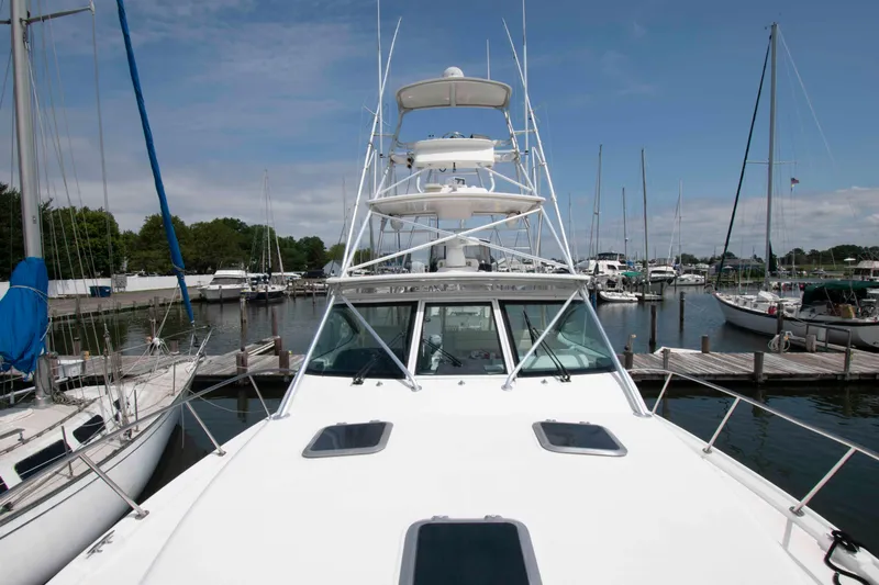 Slide: The Image of 2004 Tiara Yachts 4100 Open docked in a marina under a clear blue sky. - 15
