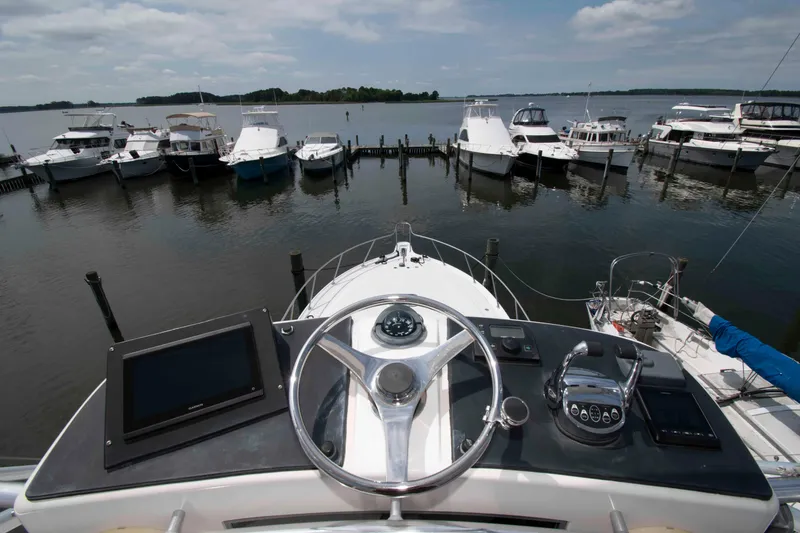 Slide: The Image of Helm view from a 2004 Tiara Yachts 4100 Open, overlooking a marina with docked boats. - 16