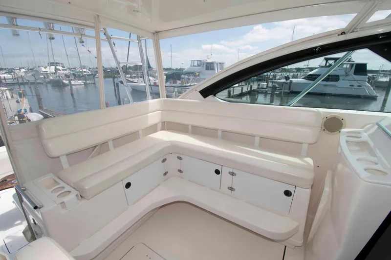 Slide: The Image of 2004 Tiara Yachts 4100 Open interior with white seating and marina view. - 8