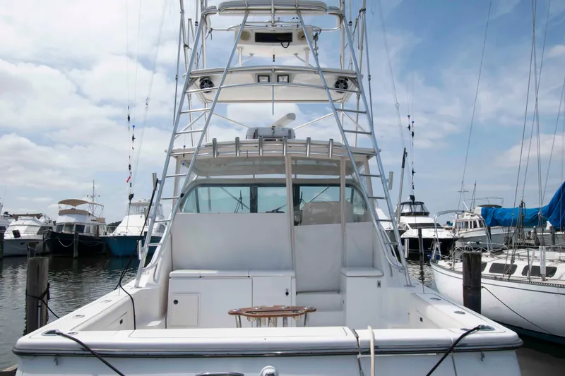 Slide: The Image of 2004 Tiara Yachts 4100 Open at marina, showcasing spacious deck and tower. - 2