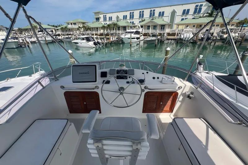 Slide: The Image of Helm of 2007 Heritage East 36 Sundeck Trawler at marina, featuring Garmin navigation system. - 4