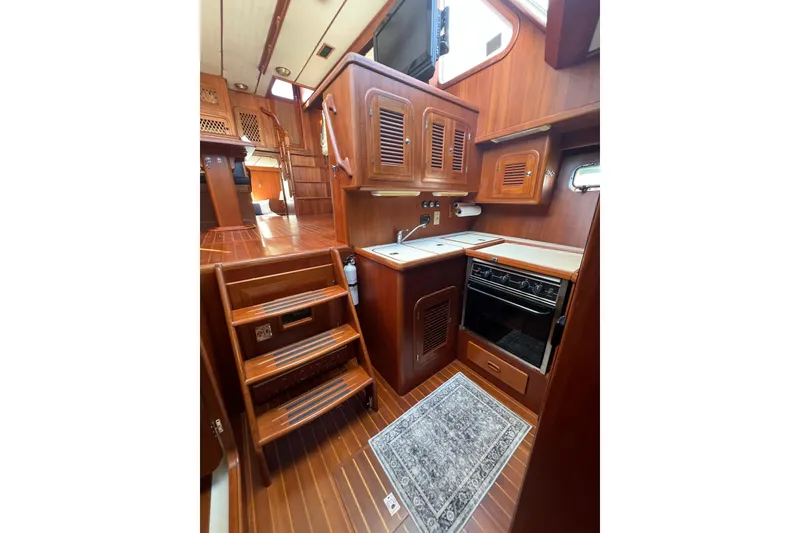 Slide: The Image of Interior of 2007 Heritage East 36 Sundeck Trawler with wooden cabinetry and compact kitchen. - 23