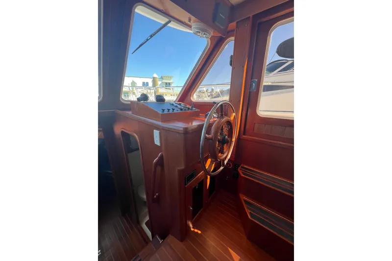 Slide: The Image of 2007 Heritage East 36 Sundeck Trawler helm with wooden steering wheel and control panel. - 13