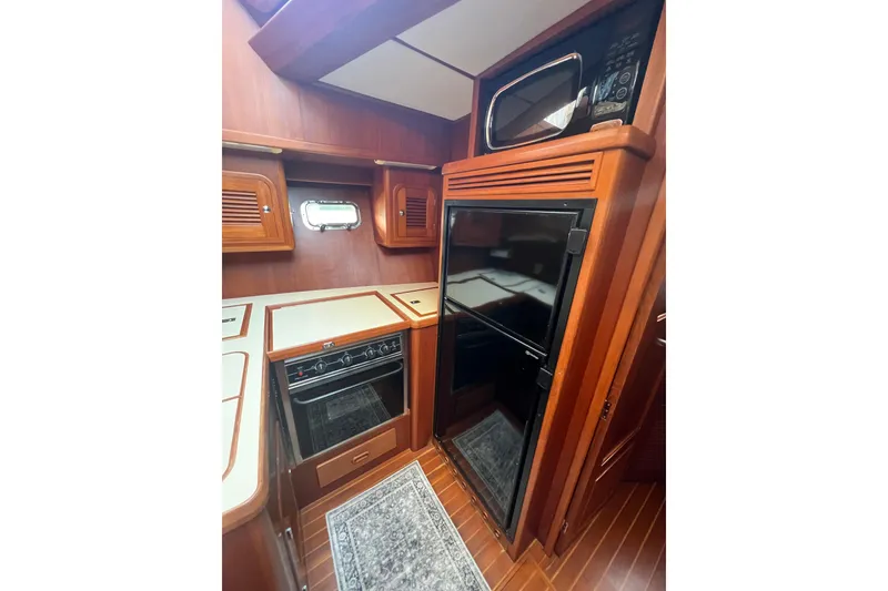 Slide: The Image of Interior of 2007 Heritage East 36 Sundeck Trawler with wood cabinetry and modern appliances. - 24