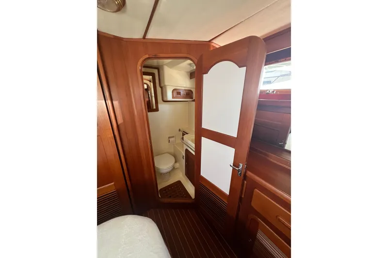 Slide: The Image of Interior of 2007 Heritage East 36 Sundeck Trawler, featuring a wooden bathroom door. - 20