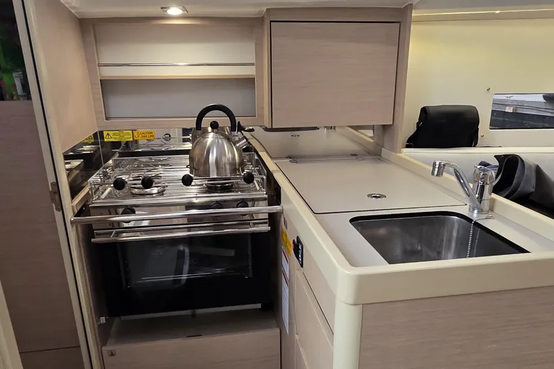 Slide: The Image of Modern kitchen in 2022 Beneteau Oceanis 30.1 yacht with stove and sink. - 16