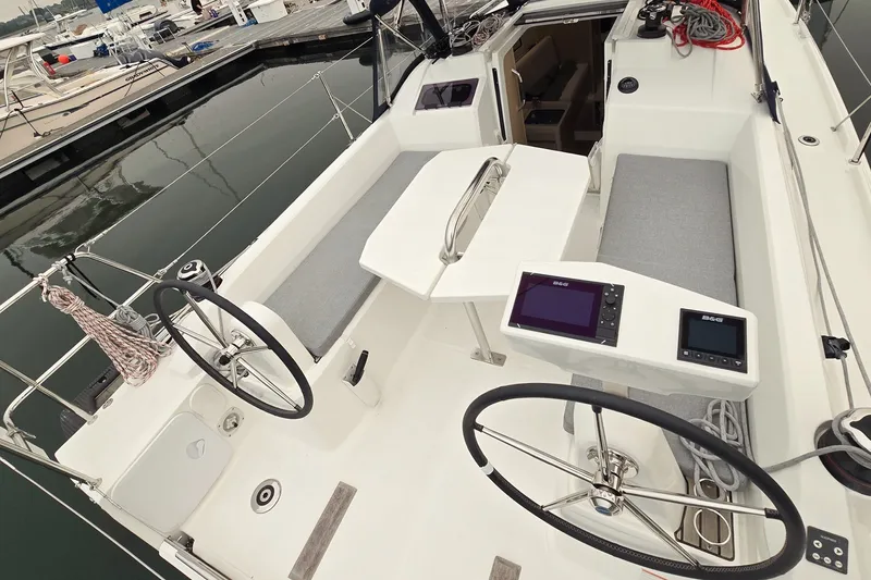 Slide: The Image of Cockpit of 2022 Beneteau Oceanis 30.1 sailboat with dual steering wheels and navigation displays. - 13