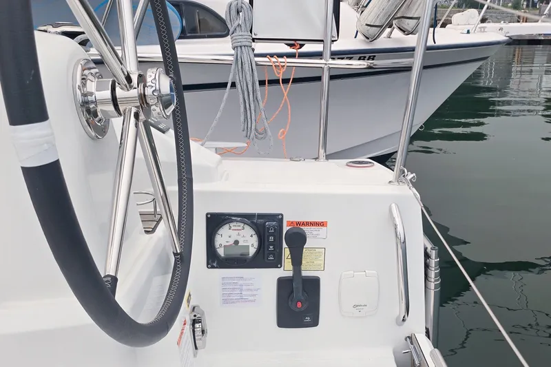 Slide: The Image of Steering wheel and controls of a 2022 Beneteau Oceanis 30.1 sailboat in a marina. - 31