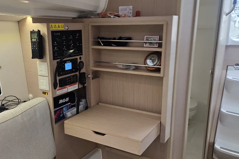 Slide: The Image of Interior of 2022 Beneteau Oceanis 30.1 yacht with navigation panel and storage shelves. - 21