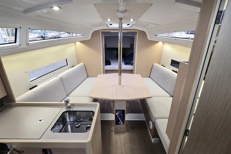 Slide: The Image of Interior of 2022 Beneteau Oceanis 30.1 yacht with modern seating and kitchenette. - 18