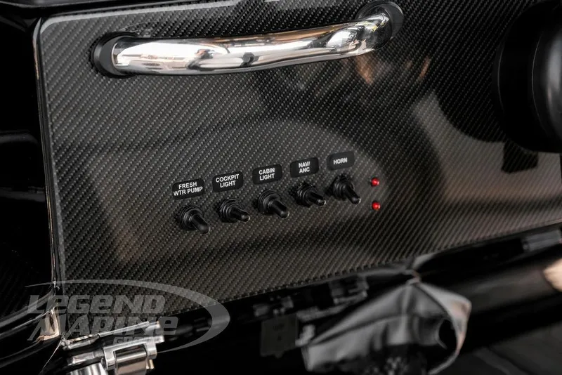 Slide: The Image of 2024 Nor-Tech 390 Sport Center Console dashboard with carbon fiber finish and control switches. - 18