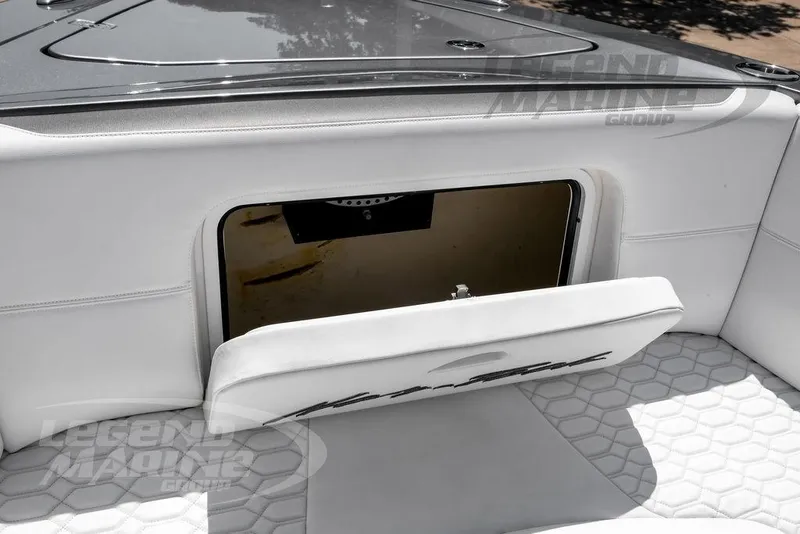 Slide: The Image of 2024 Nor-Tech 390 Sport Center Console storage compartment with white cushioned seating. - 40