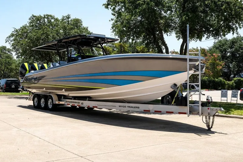 The Image of 2024 Nor-Tech 390 Sport Center Console boat on trailer, parked outdoors. - 0