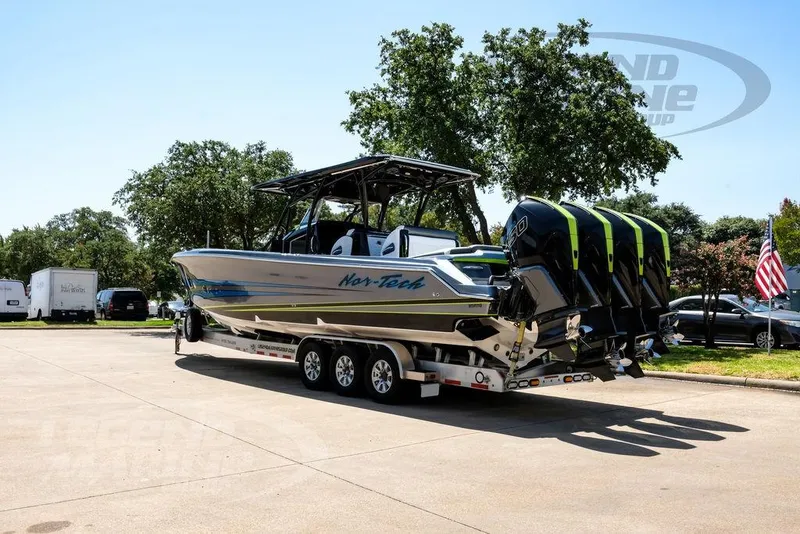 Slide: The Image of 2024 Nor-Tech 390 Sport Center Console boat on trailer, parked outdoors. - 4